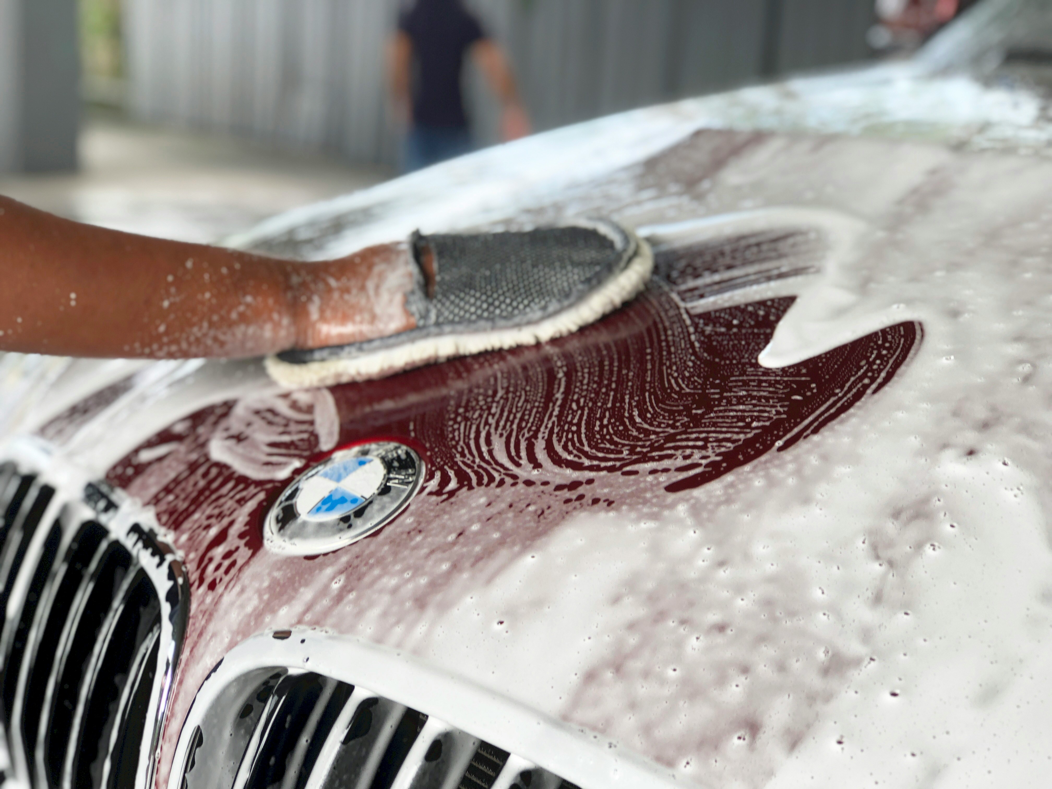 Hand washing a BMW hood with a wash mitt