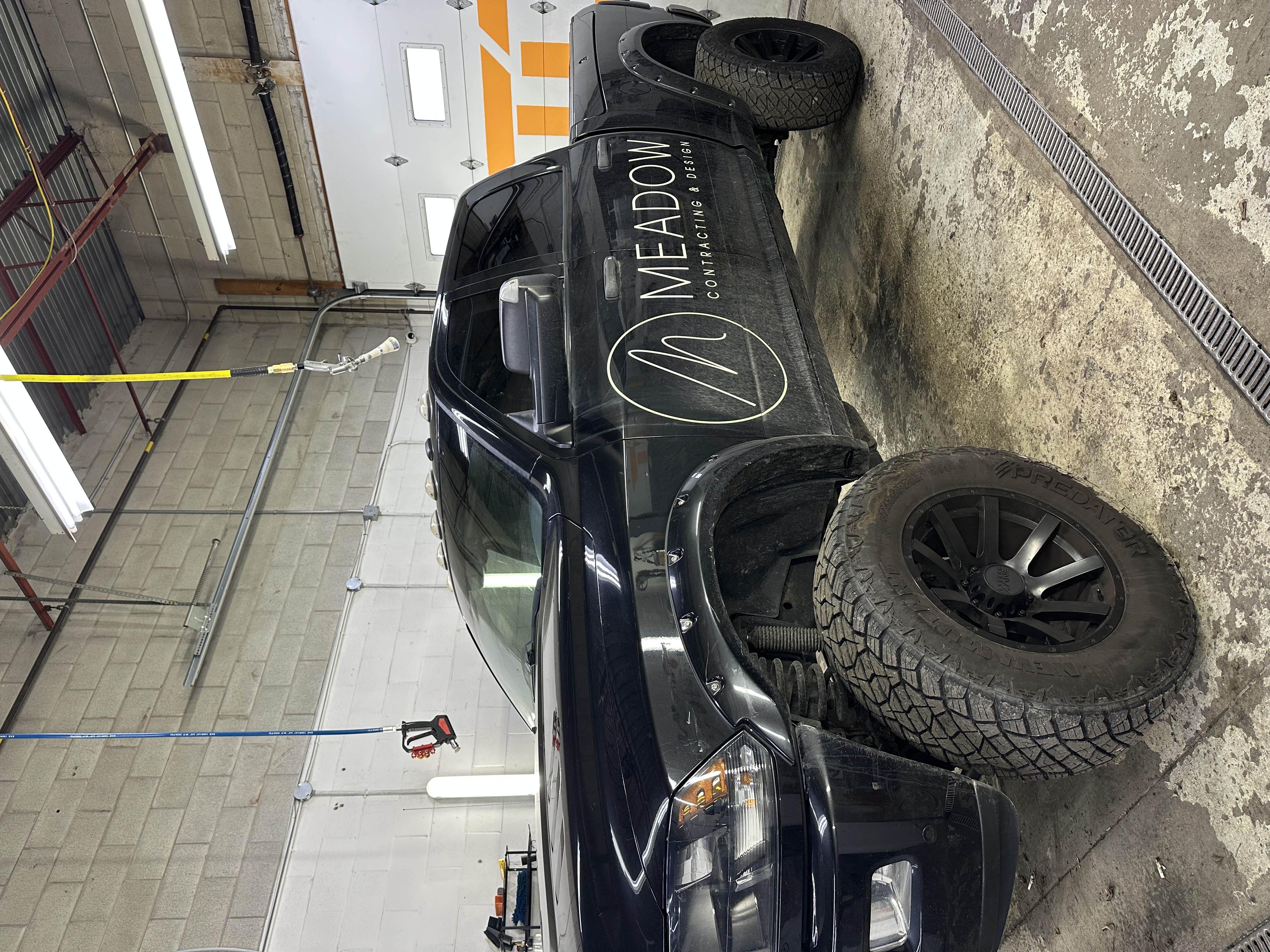 Black truck in professional detailing bay after full exterior detail
