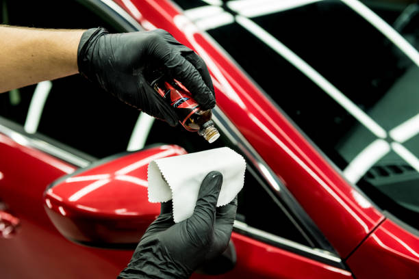 Applying ceramic coating to a red car mirror with applicator cloth